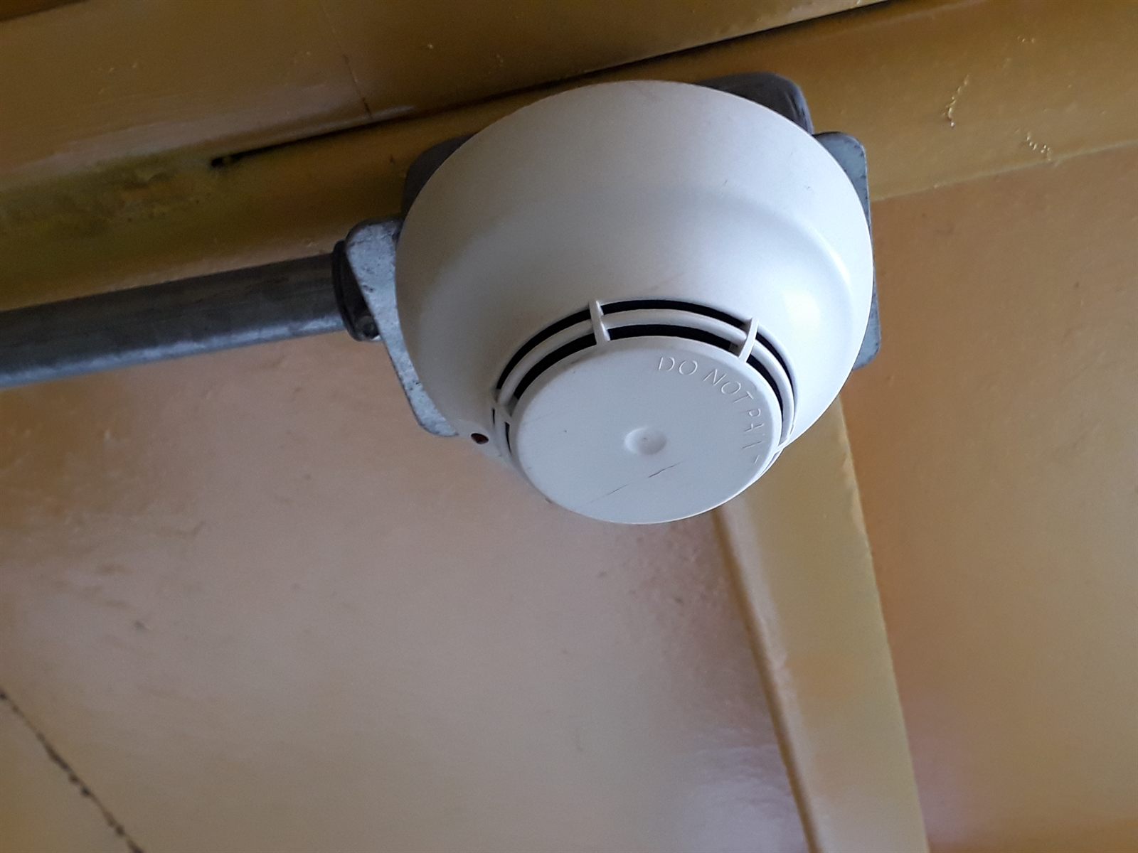 Detector de humo fotoeléctrico con base y caja de conexión, alimentado por canalización conduit EMT galvanizada según norma.