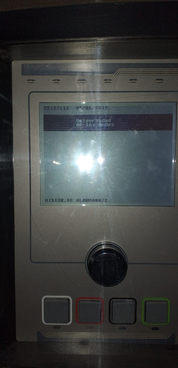 Detalle del panel de control EST3 operativo mostrando en pantalla el sistema rotulado "Universidad de los Andes", con teclas de mando y registro de historial de alarmas.